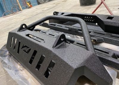 Custom grille guards and push bars coated with a high quality bedliner material by Vortex Sprayliners